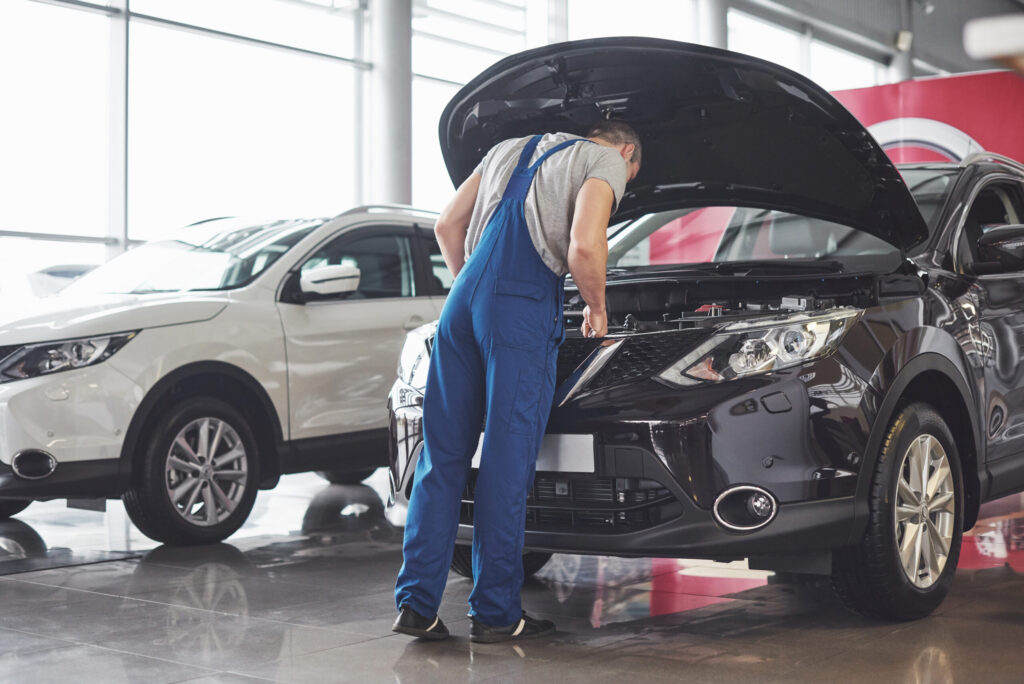 Picture showing muscular car service worker repairing vehicle.